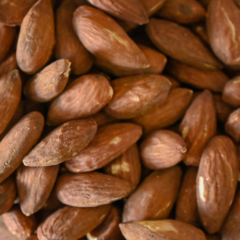 A close-up pile of brown almonds filling the frame.