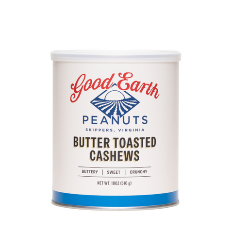 A white cylindrical canister of Good Earth Peanuts Butter Toasted Cashews, featuring a white label with red and blue branding and black text, set against a plain white background.
