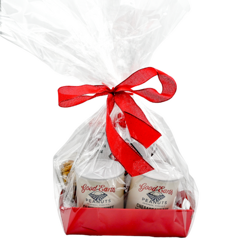 A red gift basket filled with an assortment of good earth peanuts products wrapped in cellophane with a red bow.